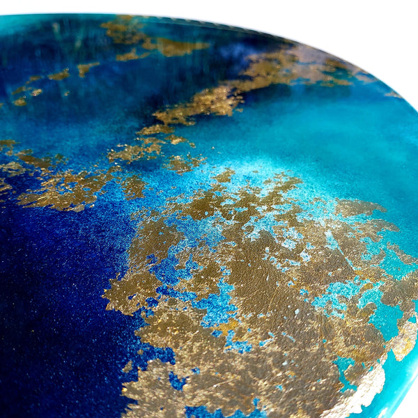 Golden Dreams is a 50cm round wall art piece created in a resin art style that features beautiful teal and blue resin and flashy gold leaf details